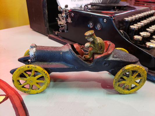 Vintage cast iron race car with driver