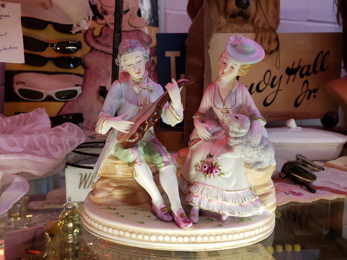 Man playing instrument to Lady with Sheep figurine