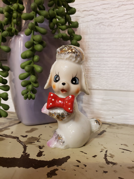 White poodle figurine with red bow